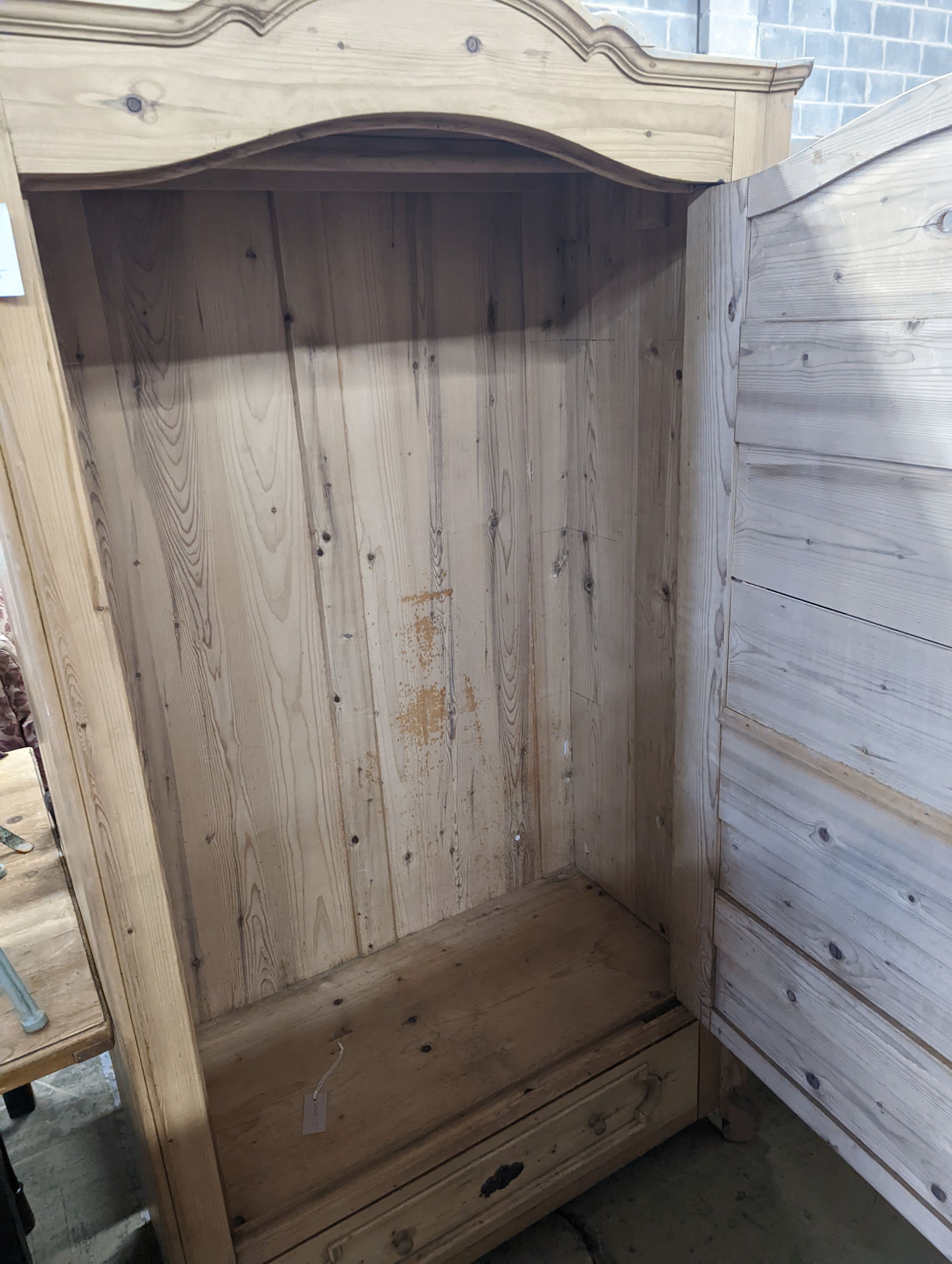 A 19th century Continental pale pine hanging cupboard with dummy drawer front, width 104cm, depth 50cm, height 183cm
